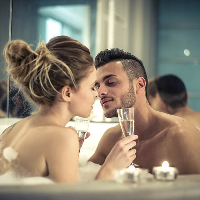 Un homme et une femme dans une baignoire avec des coupes de champagne (Istock)