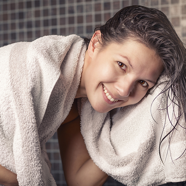Femme se sechant les cheveux avec une serviette propre au sortir de la douche (Istock)