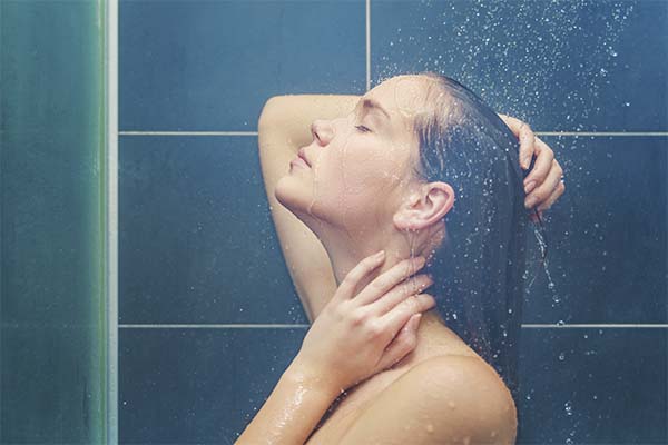 Femme sous la douche rinçant ses cheveux (iStock)